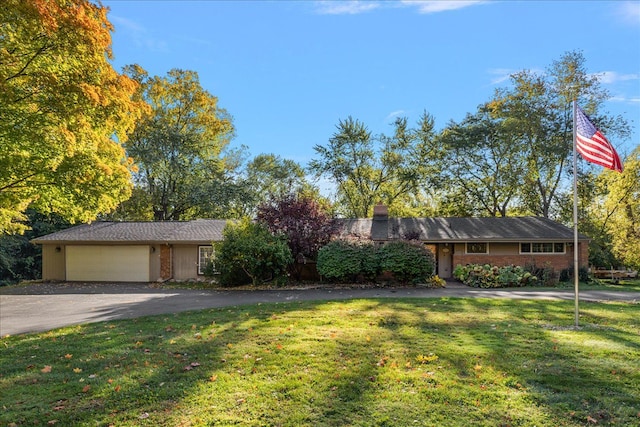 ranch-style house featuring a garage and a front lawn