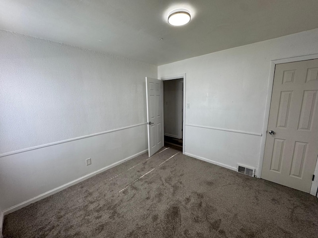 unfurnished bedroom featuring dark colored carpet