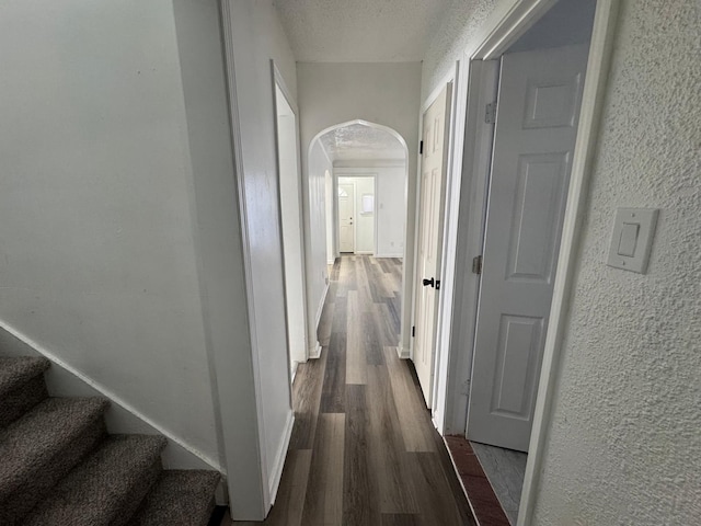 hallway featuring dark wood-type flooring and a textured ceiling