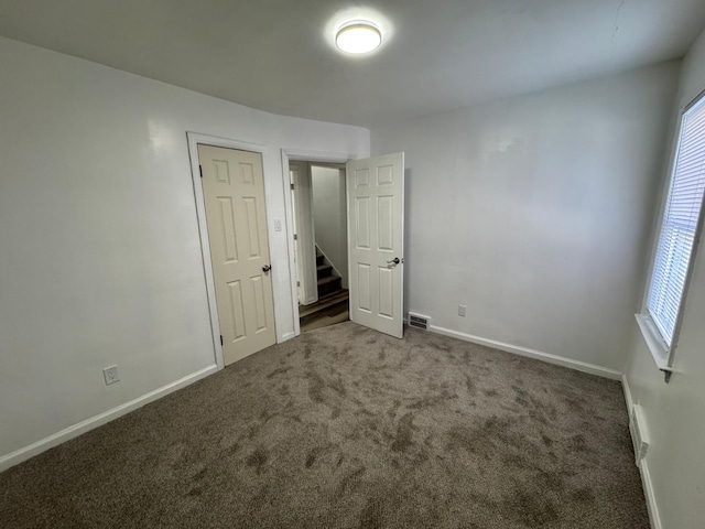 spare room with dark carpet