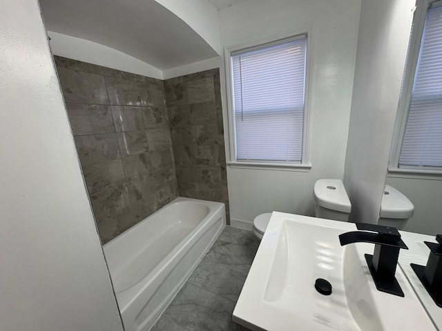 full bathroom featuring tiled shower / bath combo, sink, and toilet