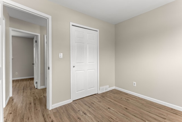 unfurnished bedroom featuring light hardwood / wood-style floors and a closet