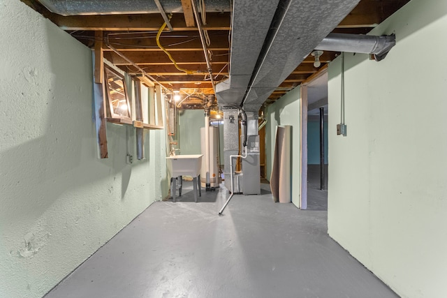 basement featuring gas water heater, sink, and heating unit