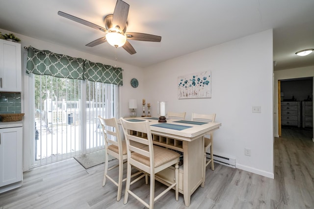 dining area featuring ceiling fan, a baseboard heating unit, and light wood-type flooring