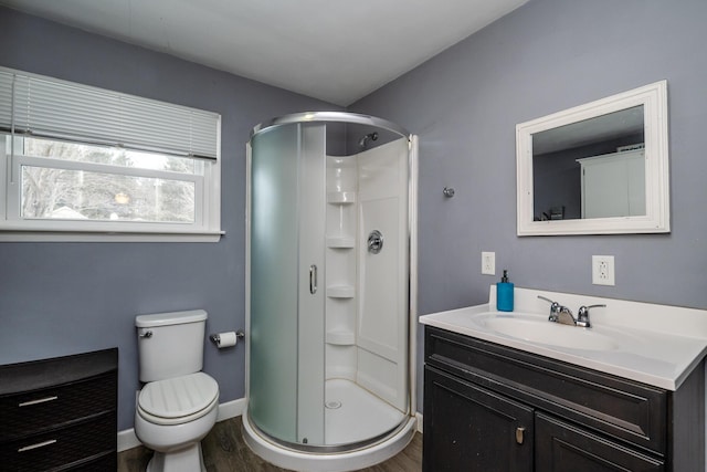 bathroom featuring vanity, toilet, a shower with door, and hardwood / wood-style floors