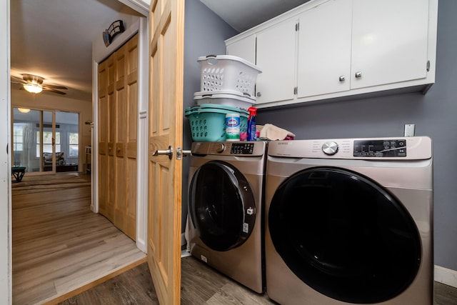 laundry room with wood-type flooring, washing machine and dryer, cabinets, and ceiling fan