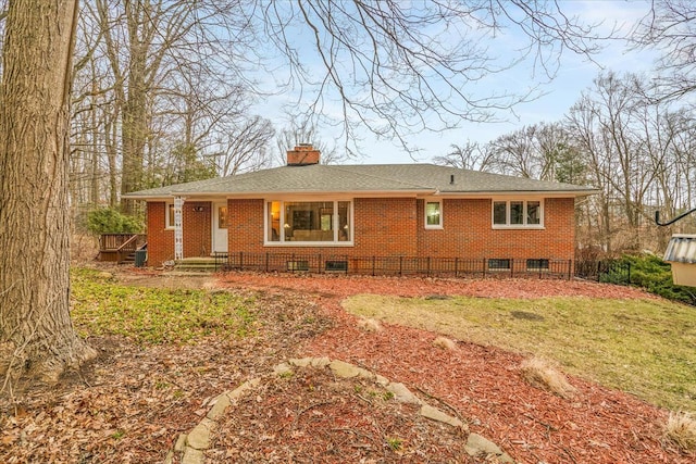 back of property with a yard, a chimney, and brick siding