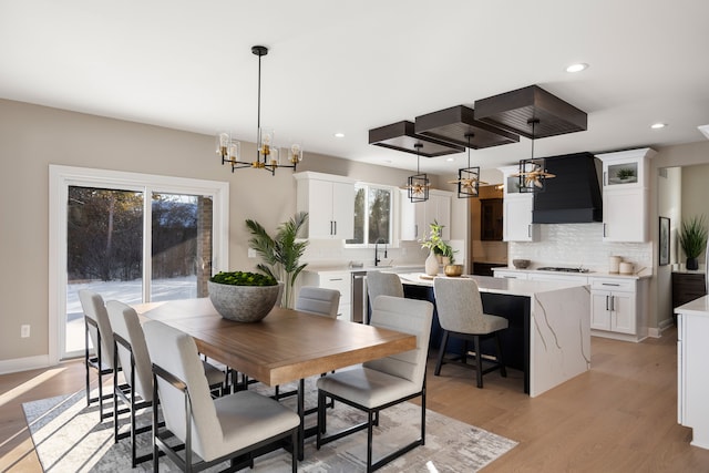 dining space featuring a chandelier, recessed lighting, baseboards, and light wood-style floors