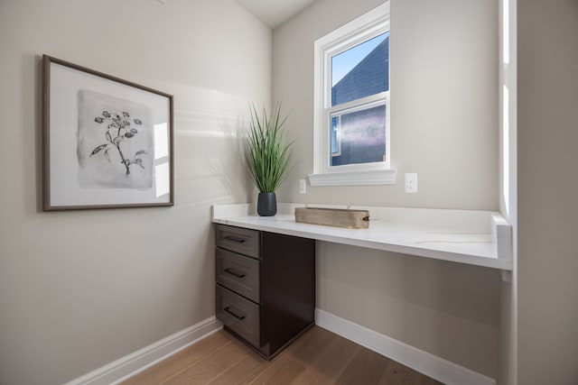 bathroom with wood finished floors, vanity, and baseboards