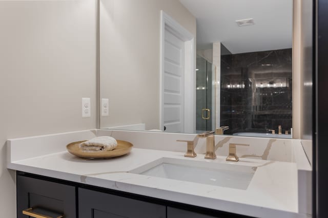 bathroom featuring a stall shower, a sink, and double vanity