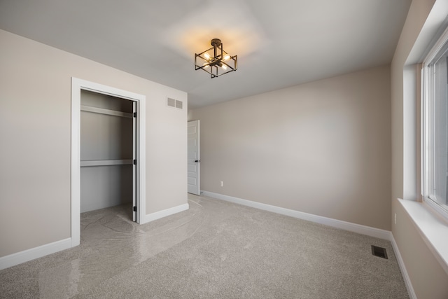 unfurnished bedroom featuring light carpet, baseboards, visible vents, and a closet