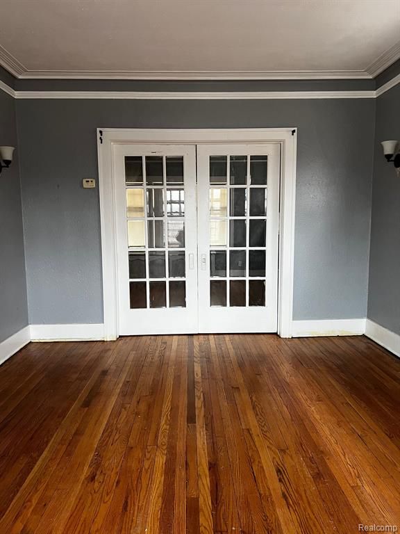 unfurnished room with hardwood / wood-style floors, ornamental molding, and french doors