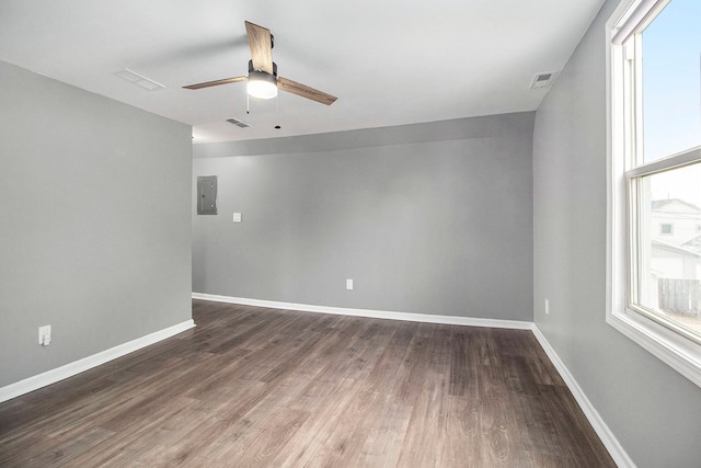 spare room with dark hardwood / wood-style flooring, electric panel, and ceiling fan