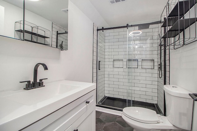 bathroom featuring vanity, toilet, and a shower with shower door