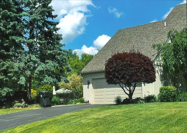 view of property exterior featuring a garage and a lawn