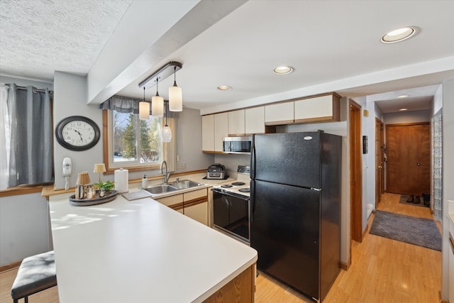 kitchen with black refrigerator, white range with electric cooktop, light hardwood / wood-style floors, pendant lighting, and sink