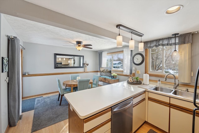 kitchen featuring sink, kitchen peninsula, light hardwood / wood-style flooring, and dishwasher