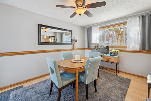 dining area featuring a textured ceiling, ceiling fan, and wood-type flooring