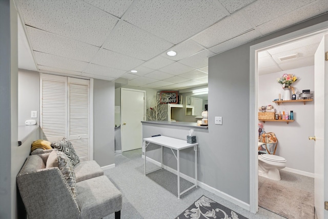 interior space featuring light carpet and a drop ceiling