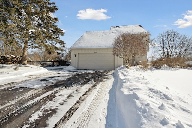 snow covered property featuring a garage