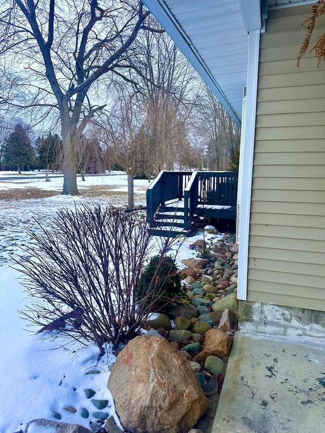 yard layered in snow featuring a deck