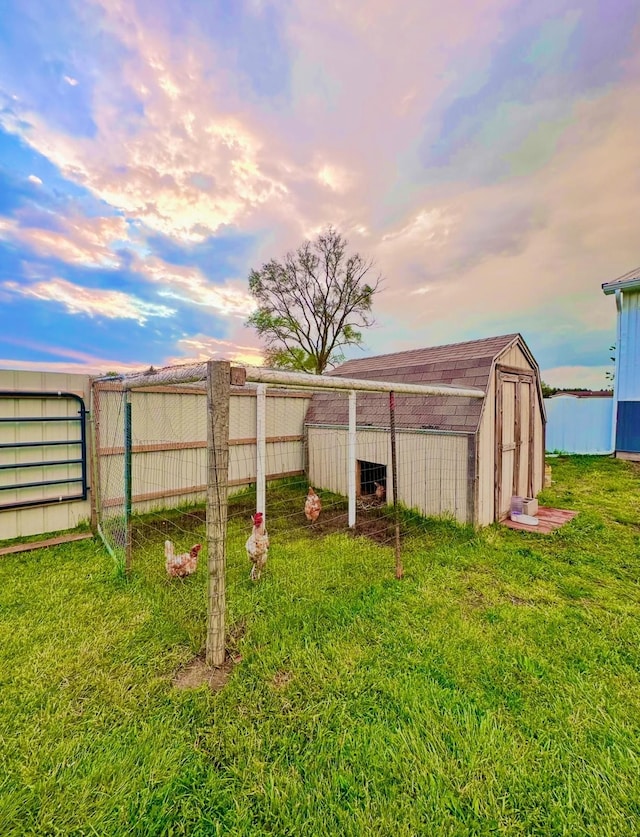 yard at dusk featuring an outbuilding