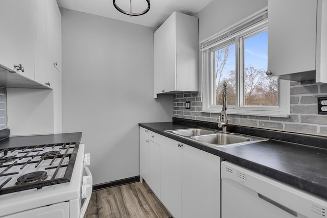 kitchen featuring white dishwasher, sink, and white cabinets