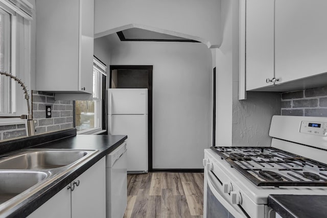 kitchen with white cabinetry, white appliances, backsplash, and light wood-type flooring