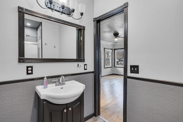 bathroom featuring vanity, a shower, tile walls, and ceiling fan