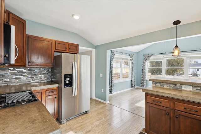 kitchen featuring lofted ceiling, hanging light fixtures, tasteful backsplash, and stainless steel appliances