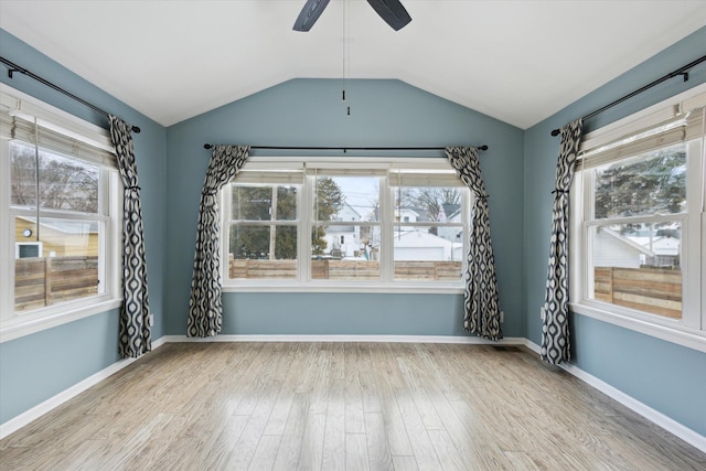 unfurnished room featuring lofted ceiling, a healthy amount of sunlight, and light wood-type flooring