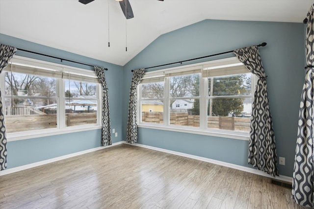 empty room featuring lofted ceiling, wood-type flooring, and ceiling fan