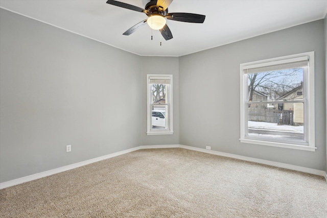 carpeted empty room with ceiling fan and a healthy amount of sunlight