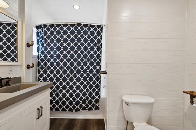 bathroom featuring walk in shower, vanity, toilet, and hardwood / wood-style floors