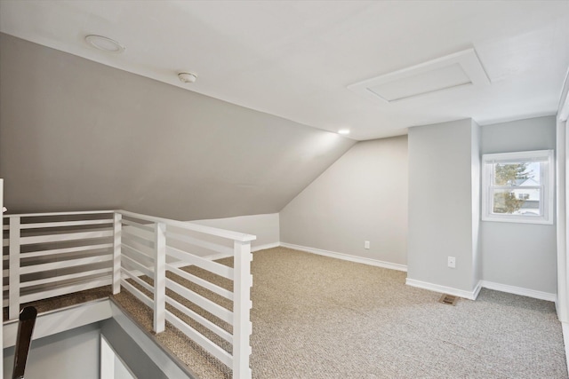 additional living space featuring vaulted ceiling and light carpet