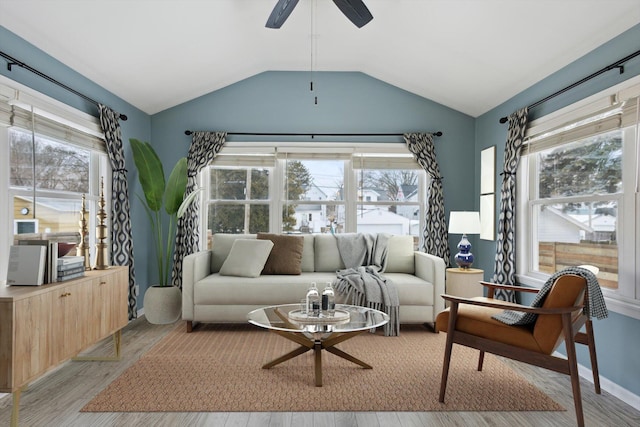 living room featuring ceiling fan, vaulted ceiling, and light wood-type flooring