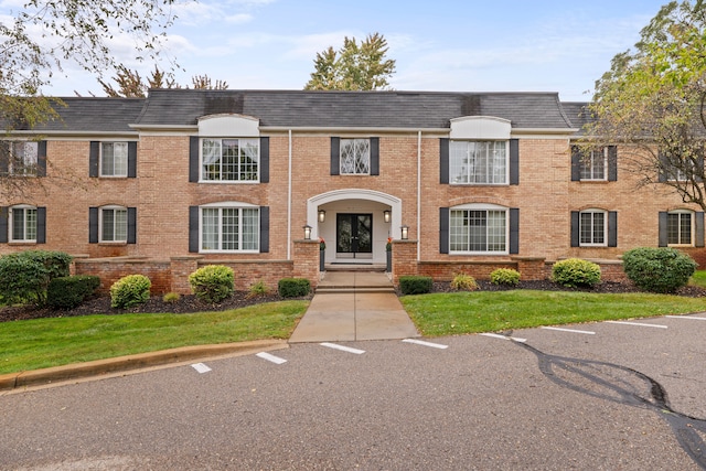 view of front of property featuring brick siding and mansard roof