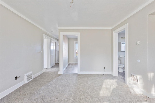 unfurnished room with ornamental molding and light colored carpet