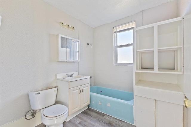 full bathroom with wood-type flooring, toilet, vanity, and tiled shower / bath