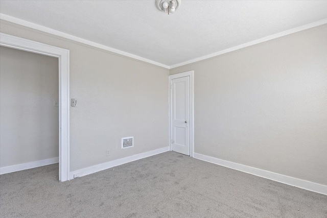 carpeted spare room featuring crown molding