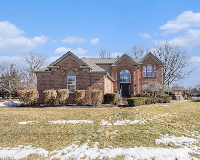 traditional-style home with a front lawn and brick siding