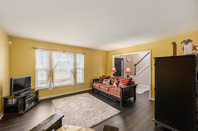 living area with baseboards, stairway, and dark wood-type flooring