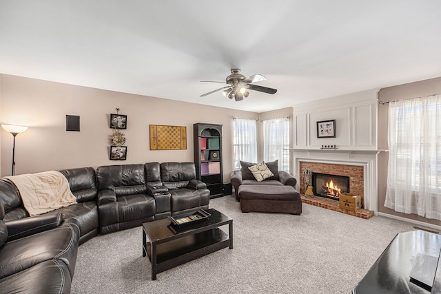 carpeted living area with ceiling fan and a fireplace