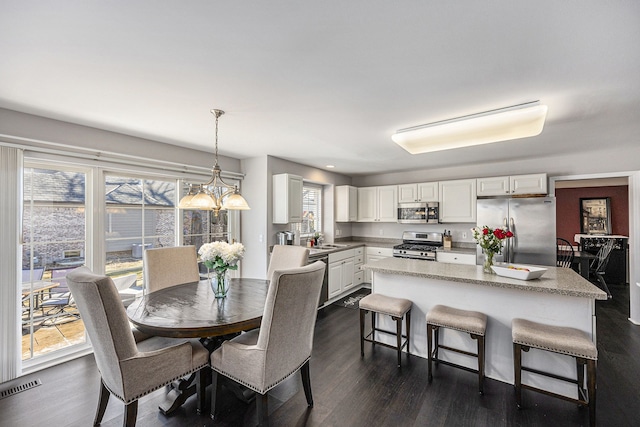 dining space with visible vents and dark wood finished floors