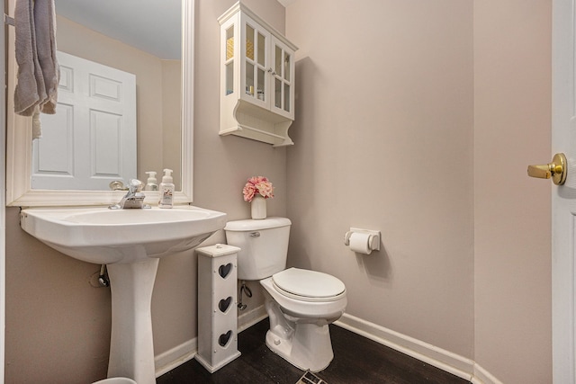 bathroom featuring baseboards, toilet, and wood finished floors