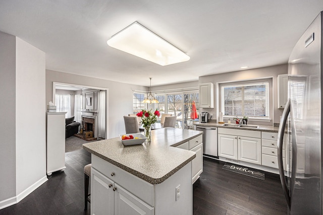54354 Bryce Canyon Trl, Macomb, MI 48042 - kitchen featuring white cabinets, stainless steel appliances, a sink, dark wood-style flooring, and a kitchen island