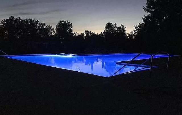 54354 Bryce Canyon Trl, Macomb, MI 48042 - pool at dusk featuring an outdoor pool