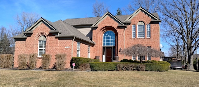 54354 Bryce Canyon Trl, Macomb, MI 48042 - traditional-style house featuring a front lawn, a trampoline, a shingled roof, and brick siding