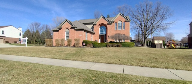 54354 Bryce Canyon Trl, Macomb, MI 48042 - traditional home featuring a front lawn, a playground, and brick siding