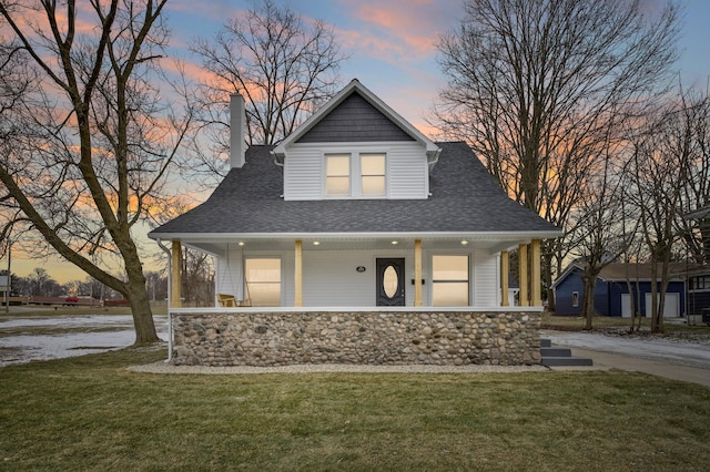 view of front of home featuring covered porch and a lawn